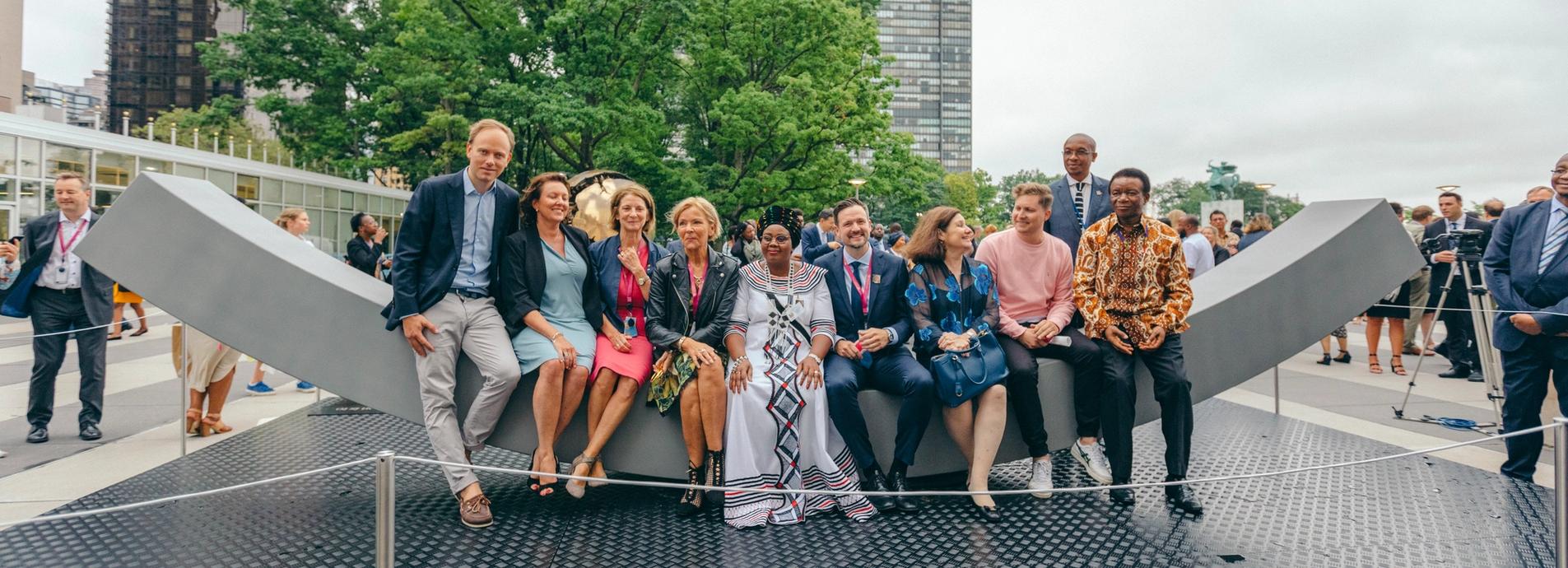 The peace bench with a big group of people sitting on the bench.