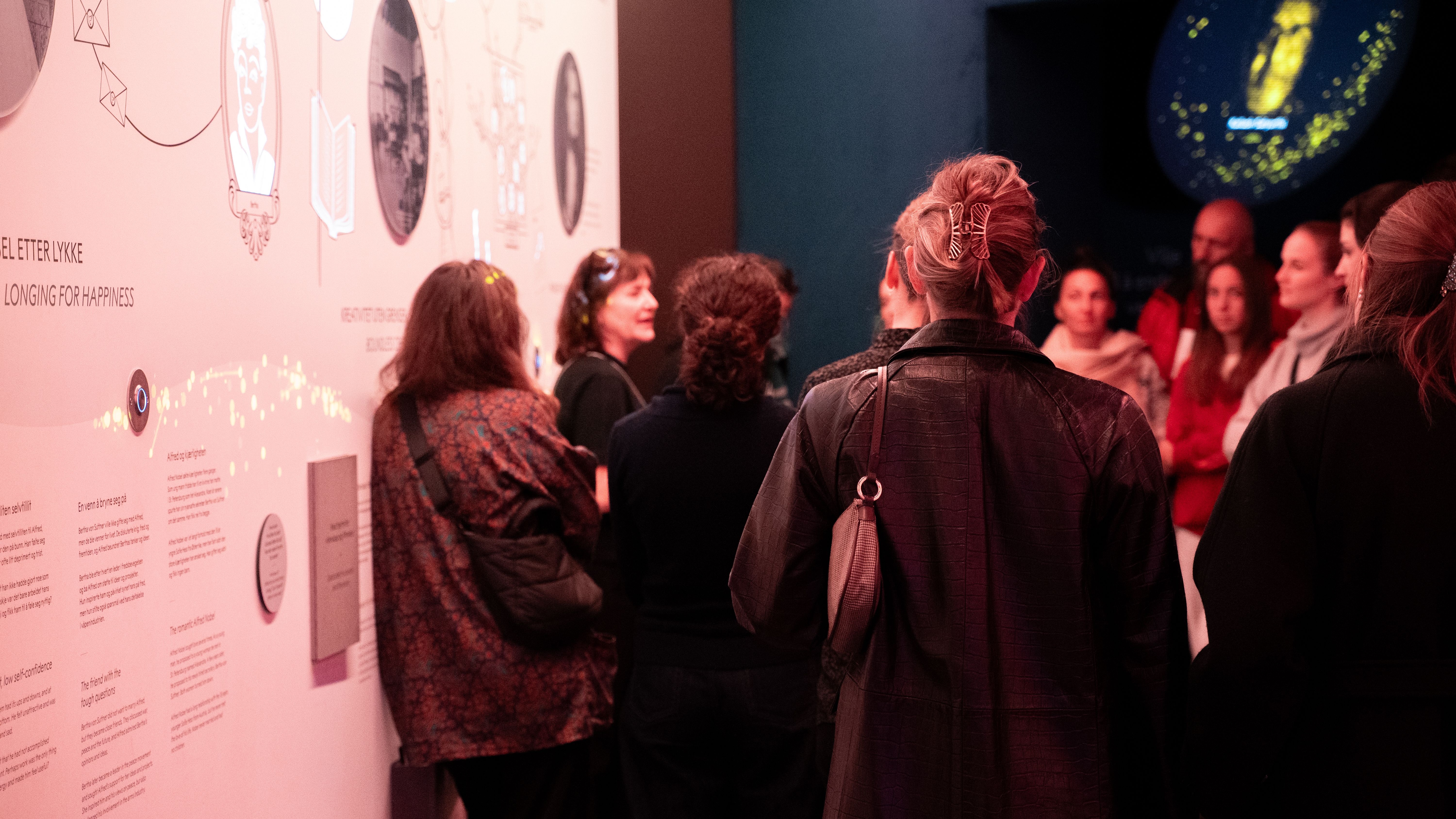 Guided tour in a exhibition with people listening and watching the guided tour.
