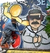 A man with grafitti of maduro in handcuffs.