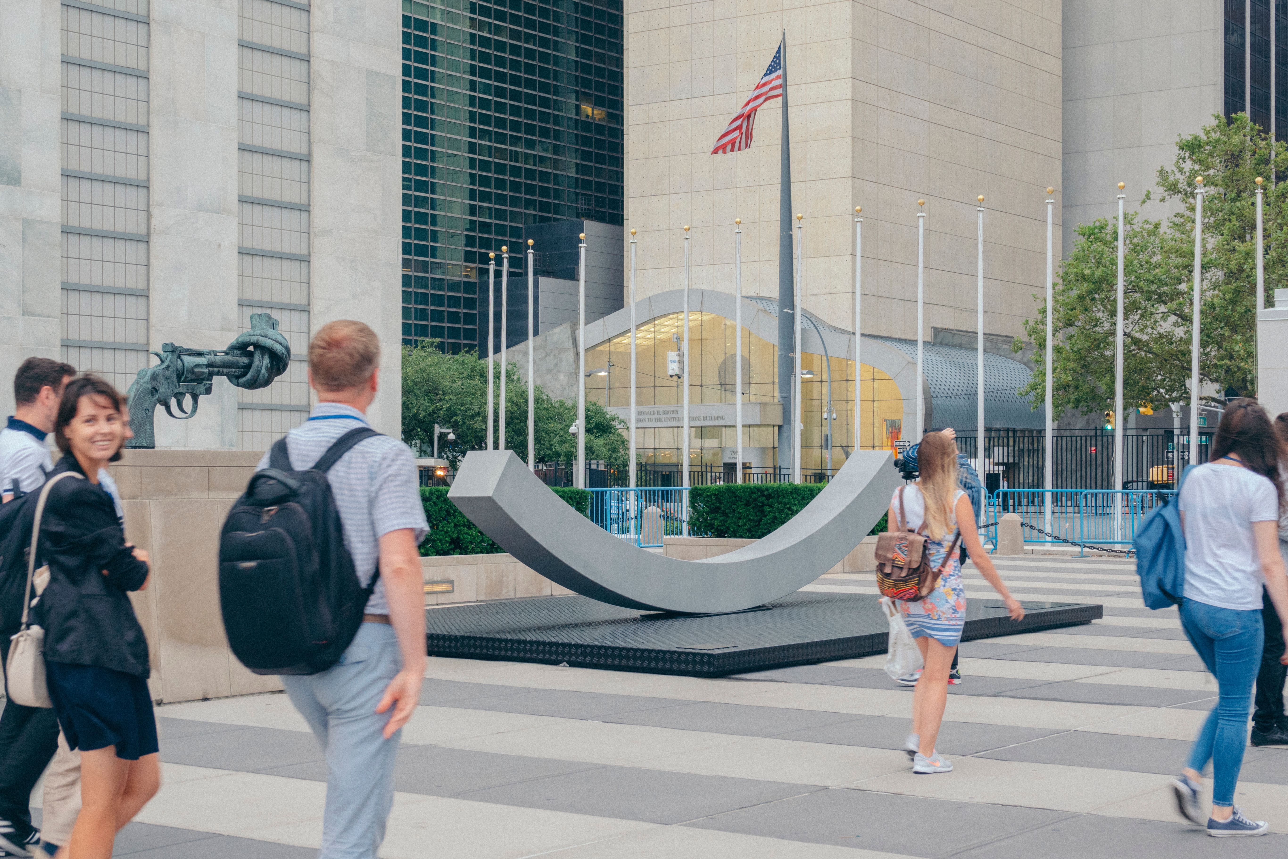 The peace bench, people walking past, american flag in the background.