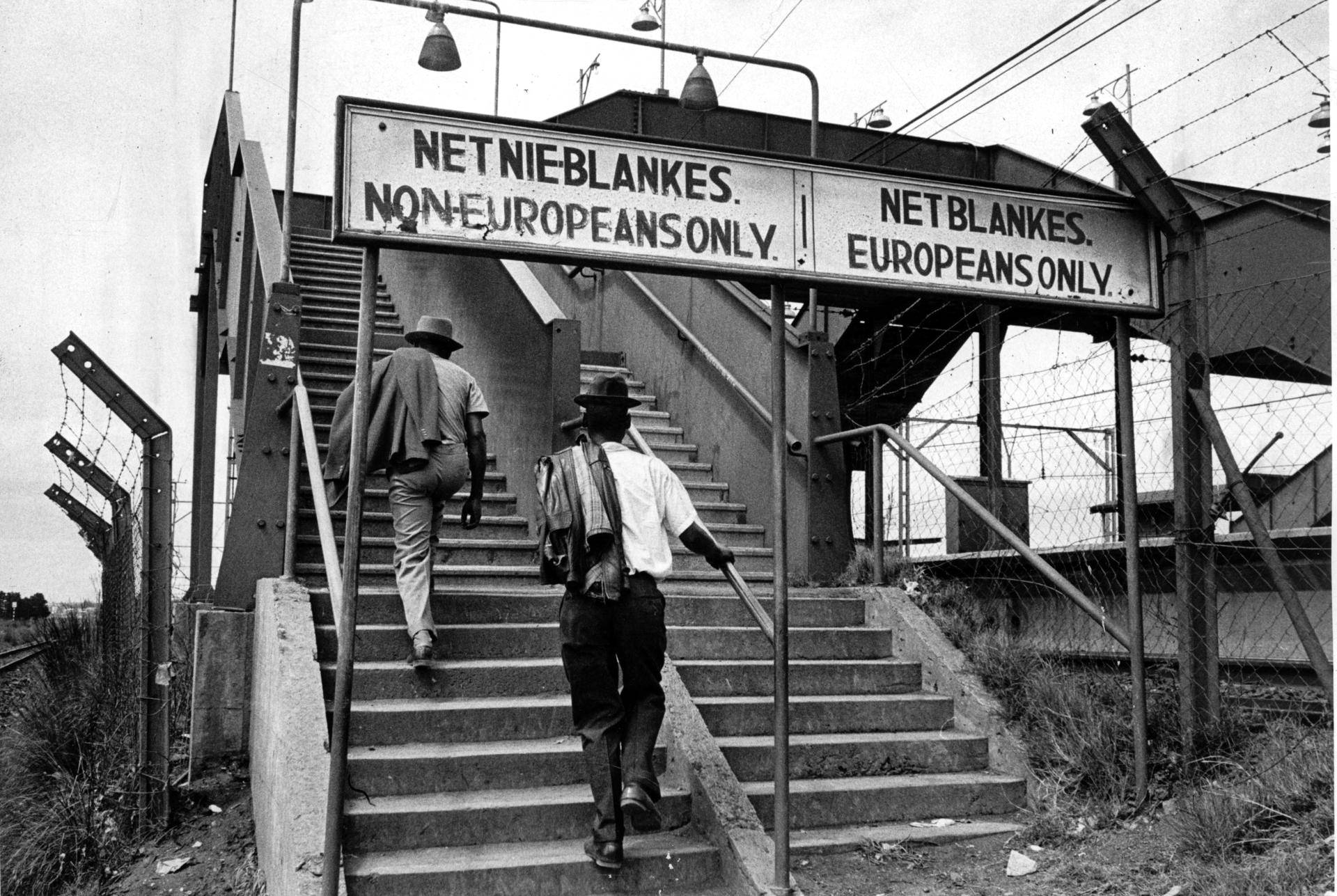 Segregational signs at a South-African train station, black and white photo from the 80s.