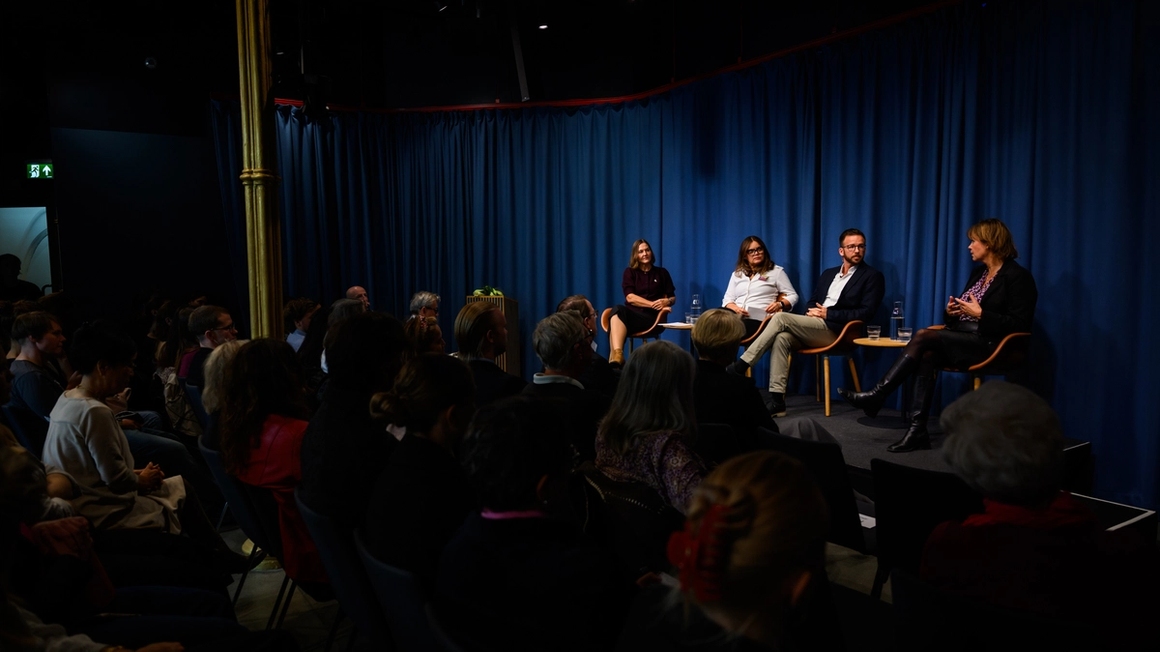 Audience watching a panel on stage.