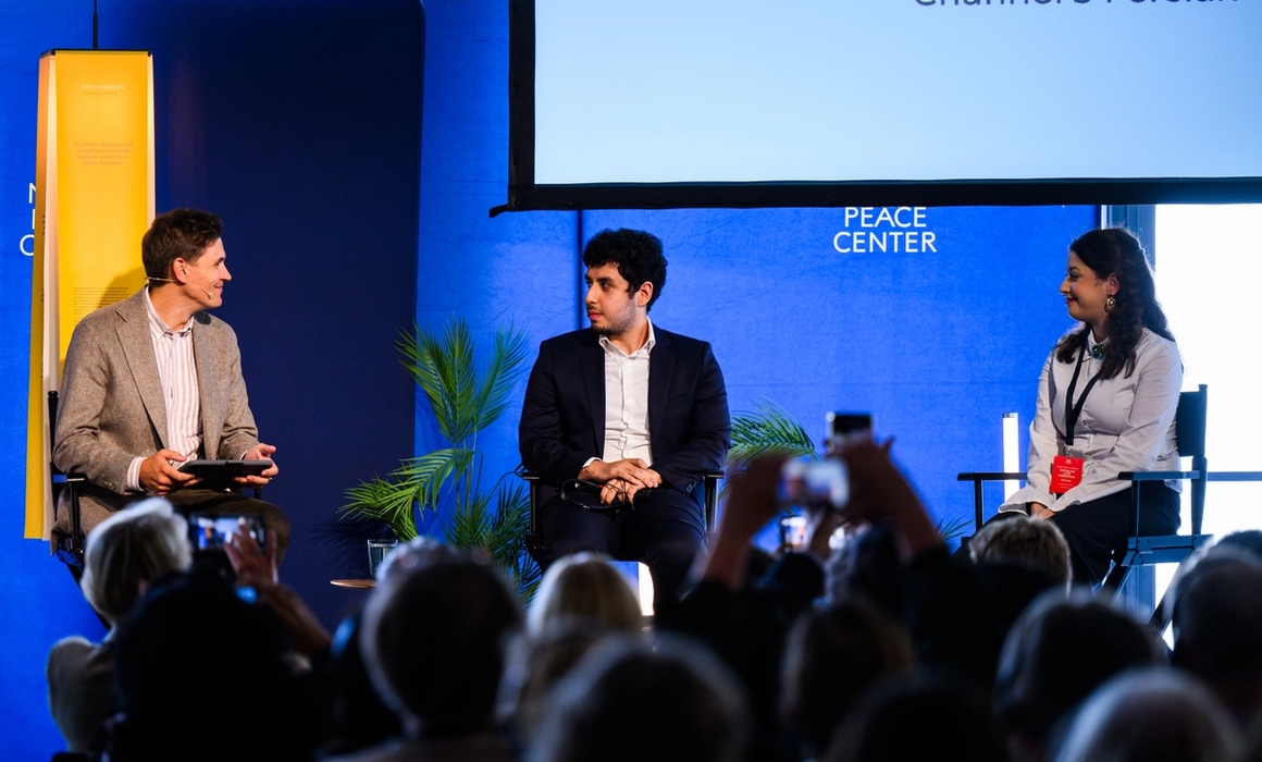 panelists on stage and audience watching