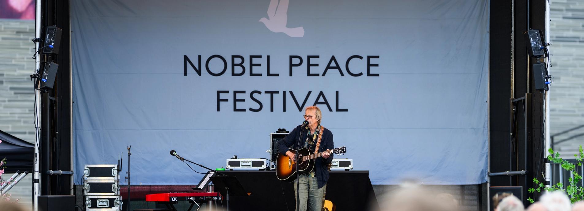 Lars Lillo On stage with guitar singing.