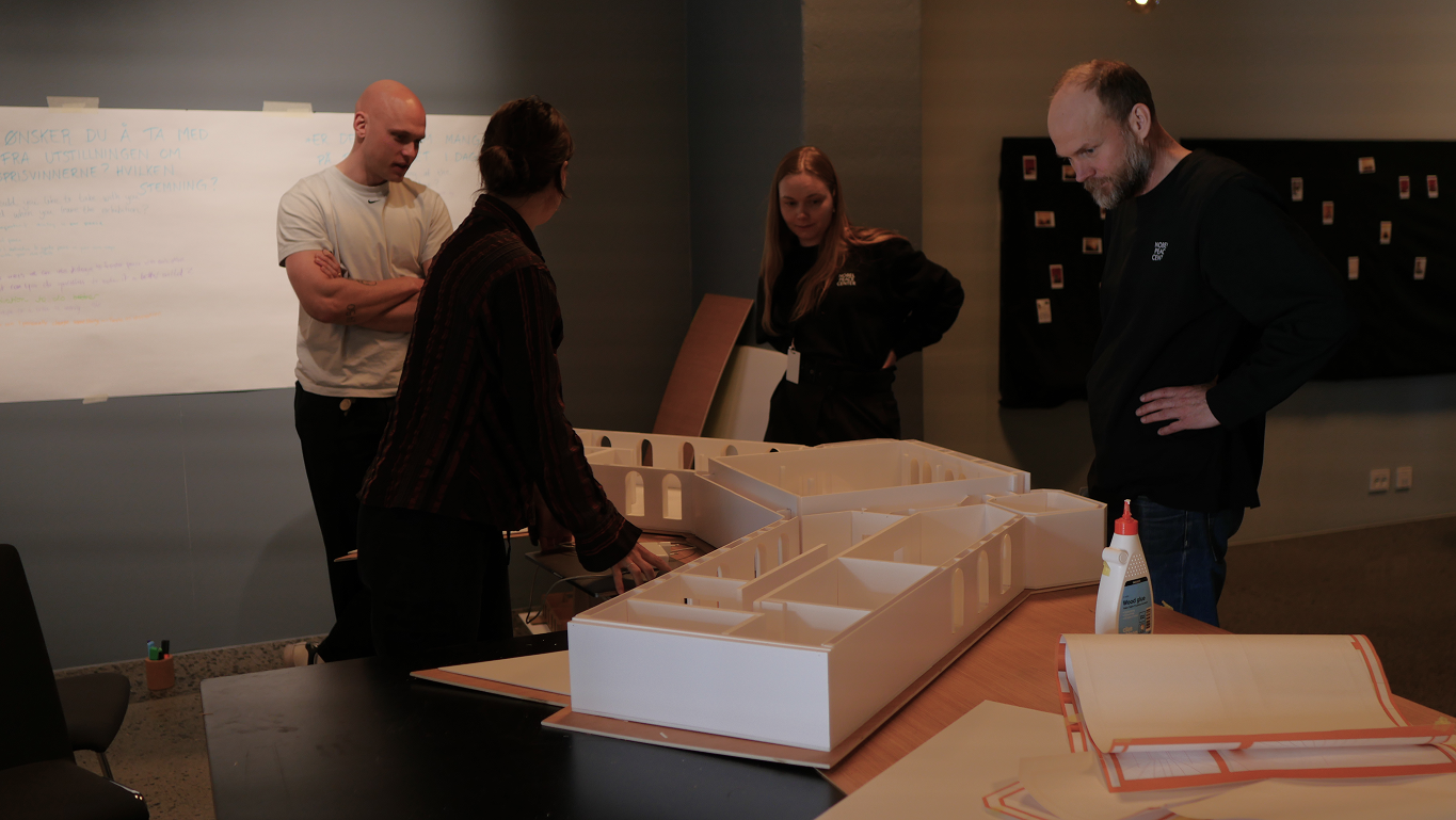People gathered around a model of the nobel peace center, planning a new exhibition.