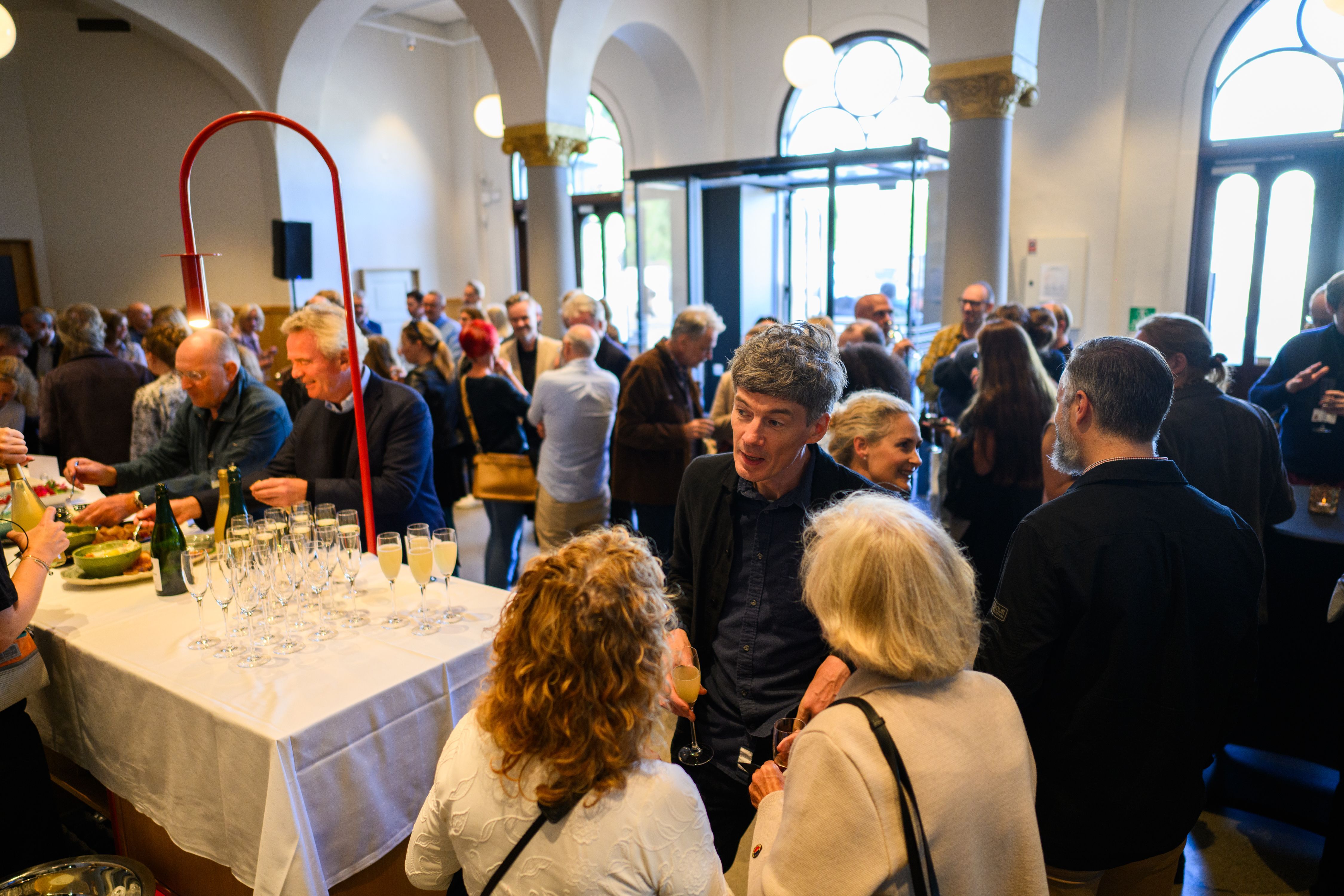 when the entry hall is full of people during an event, the front desk has been transformed into a white clothed table with welcome drinks and snacks.