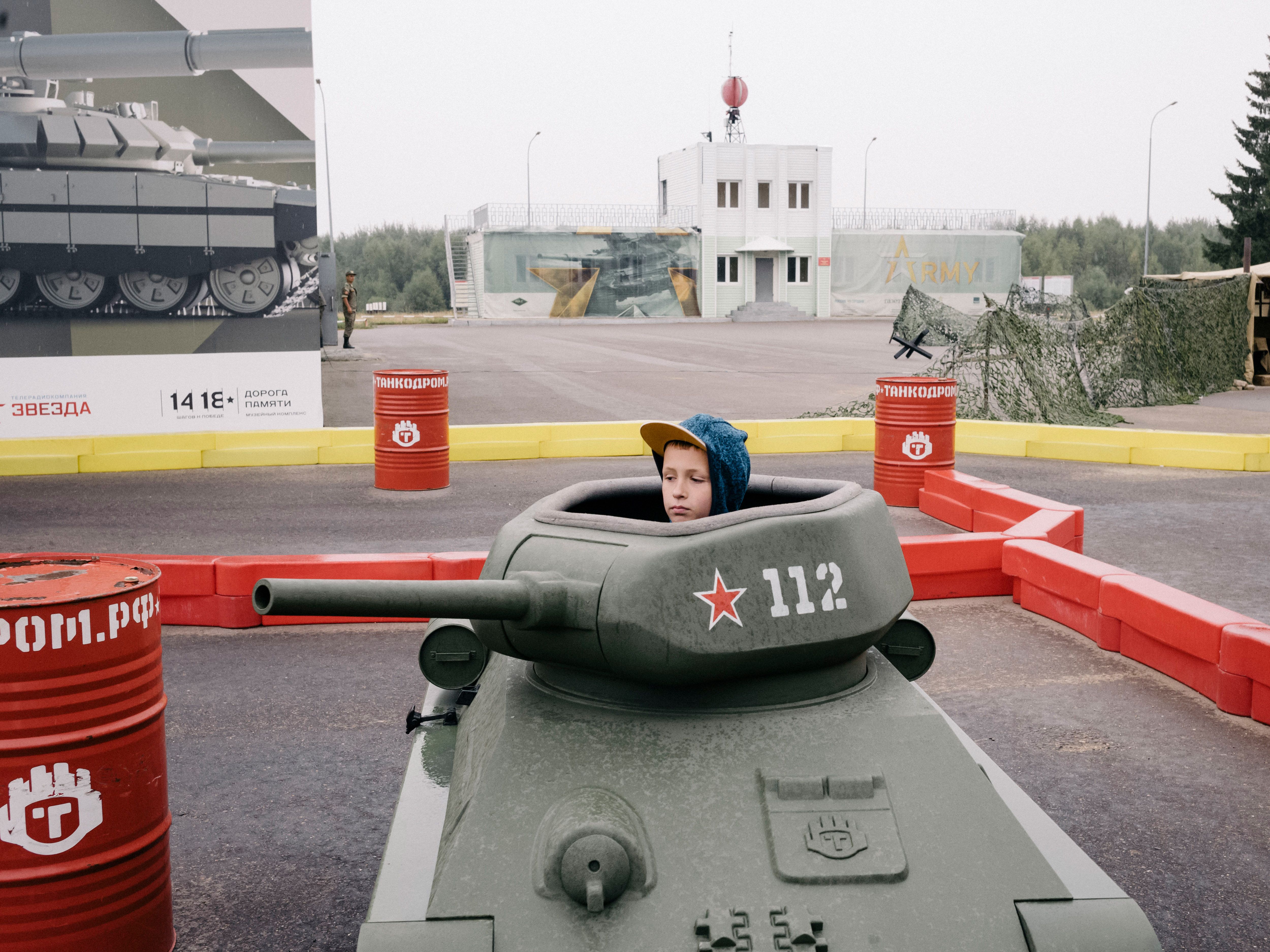 little boy sitting in a toy tank.