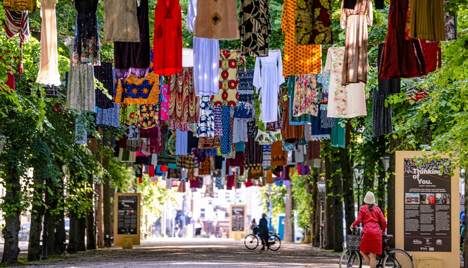 dresses hanging on strings, above a street.