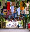 dresses hanging on strings, above a street.
