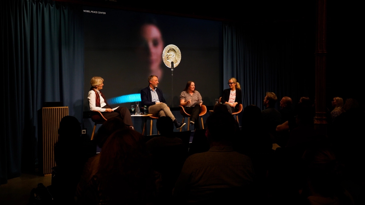 a panel on stage, conversing