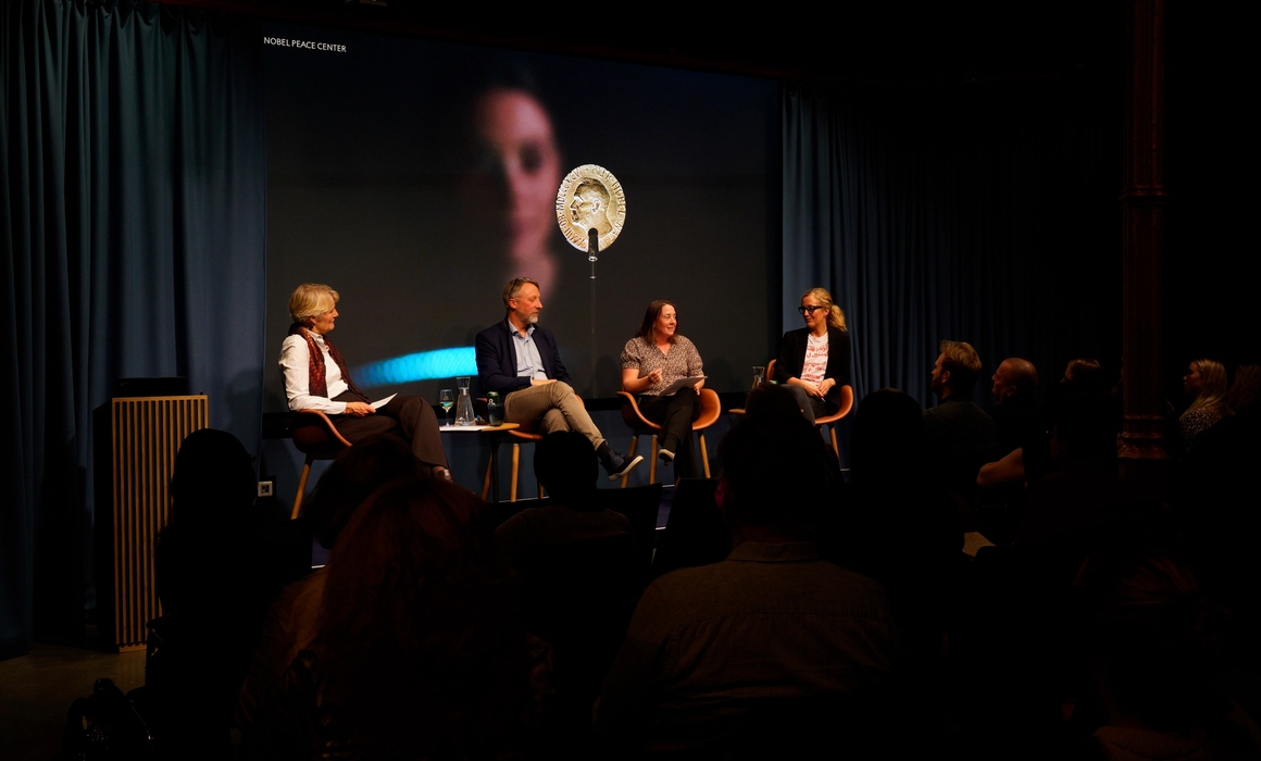 a panel on stage, conversing