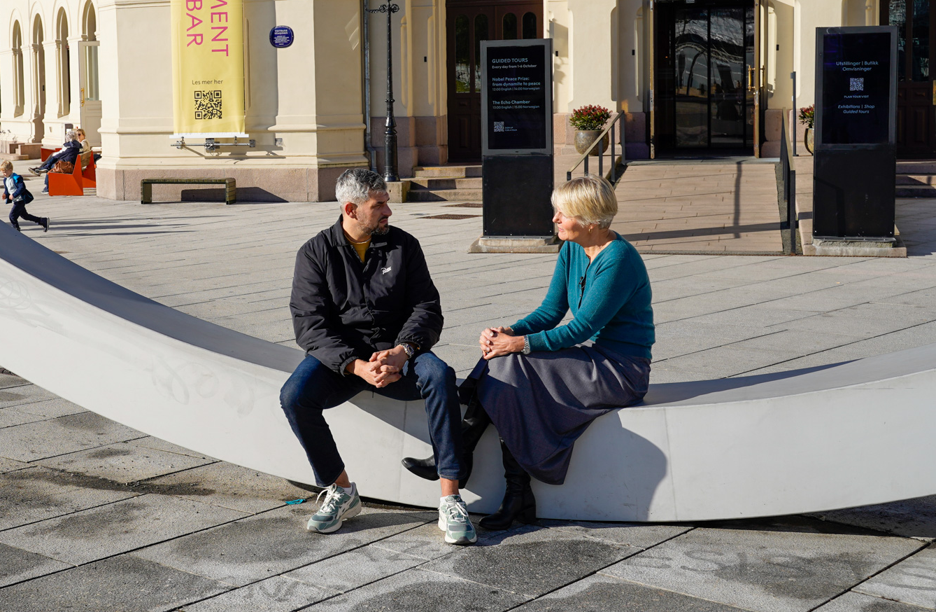 two people on a bench in dialogue.