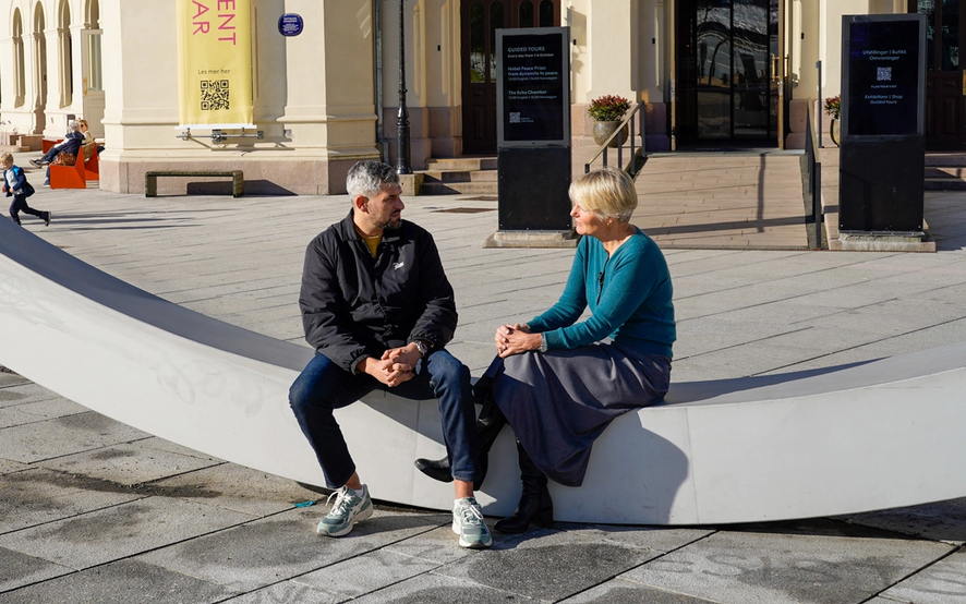 two people on a bench in dialogue.