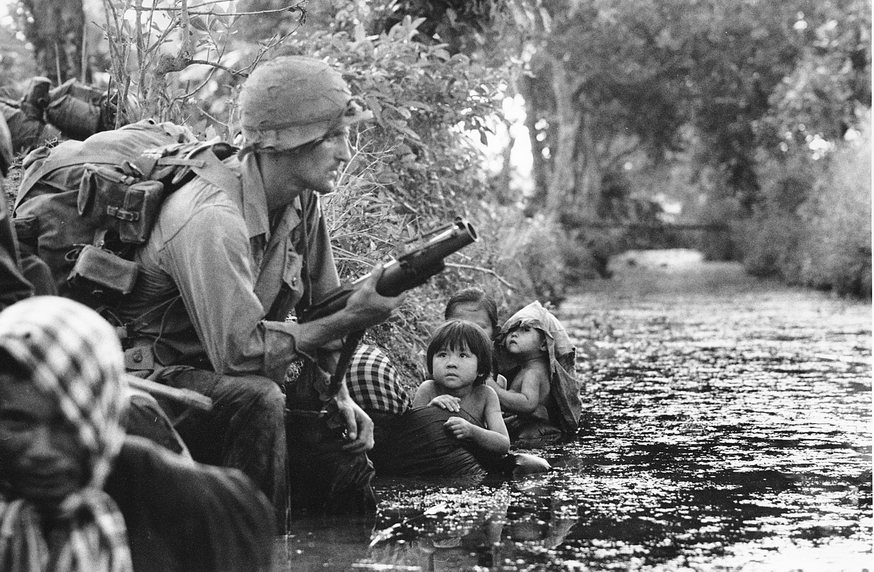 Historical photo showing a soldier and civilians.