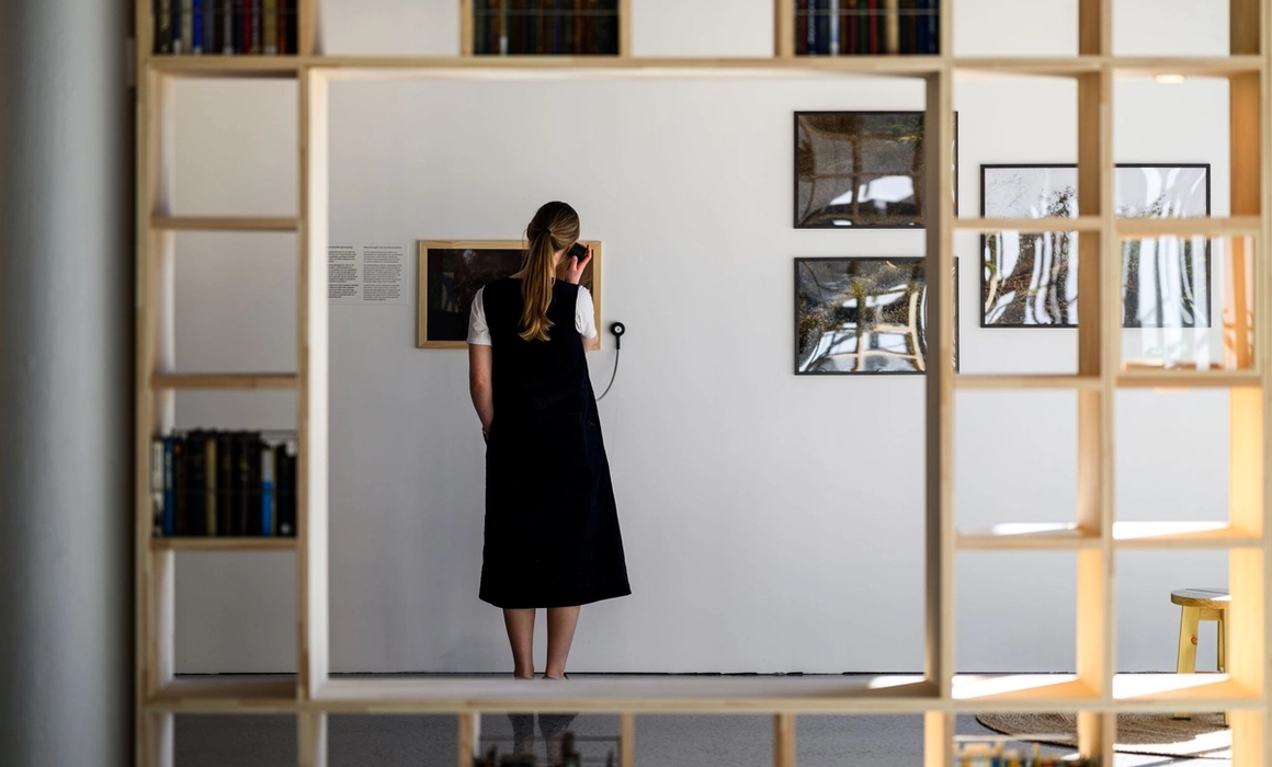the exhibition, woman listening to a display