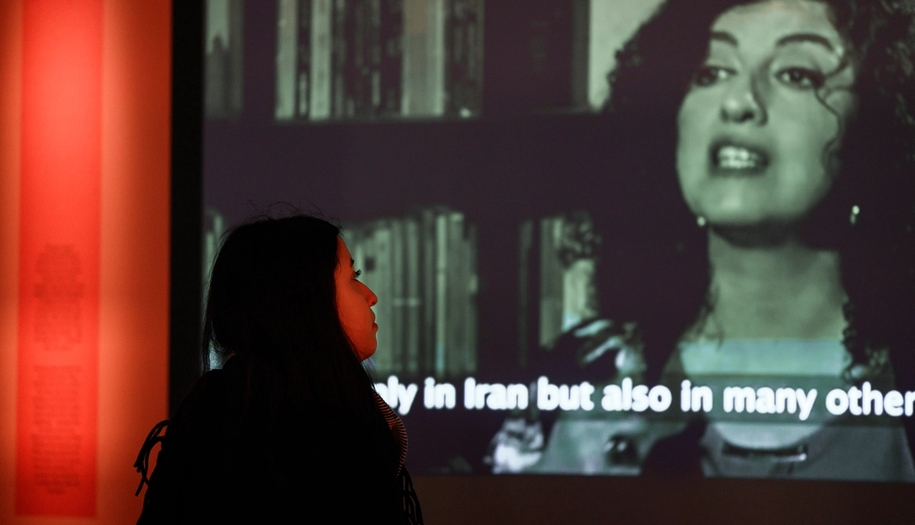 Kiana Rahmani watches a snippet from the film "white torture" in the peace prize exhibition