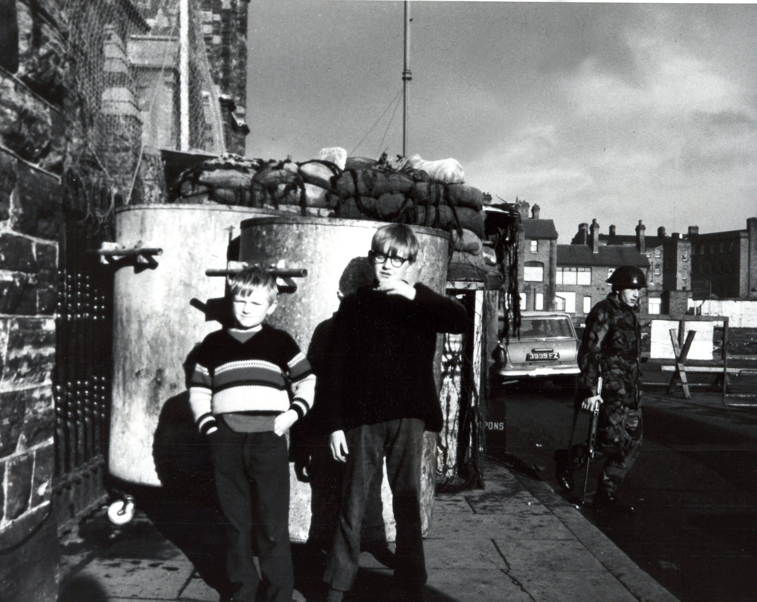 Two boys in front of the peace brigade during civil war in Northern ireland 1970s.