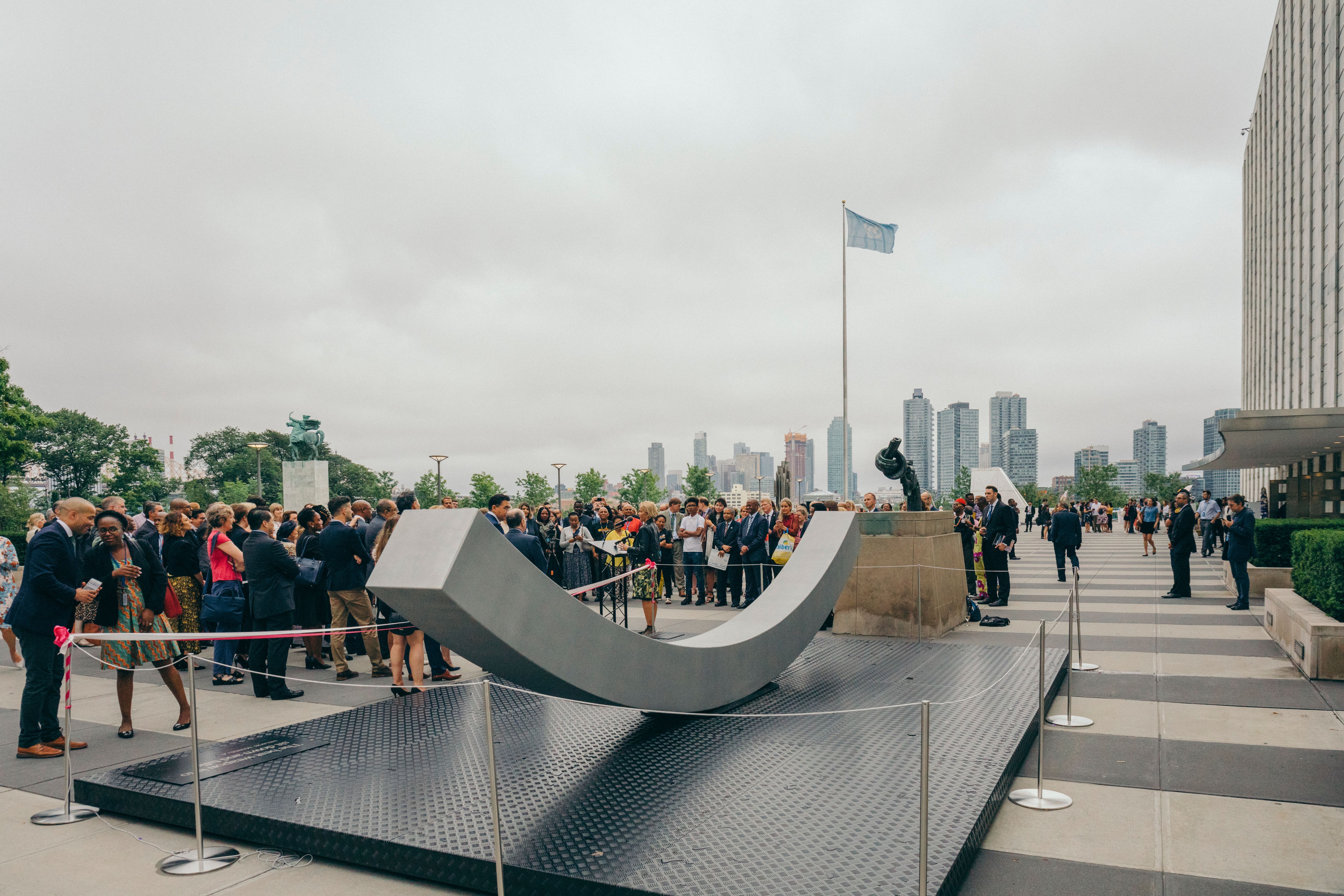 The peace bench with a big group of people surrounding it-