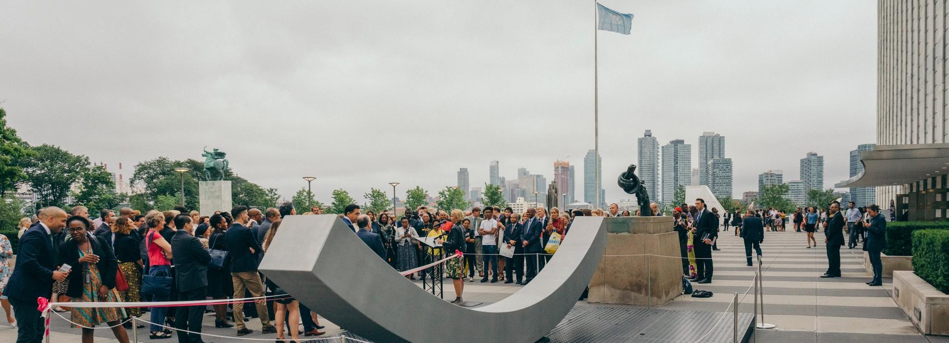 The peace bench with a big group of people surrounding it-