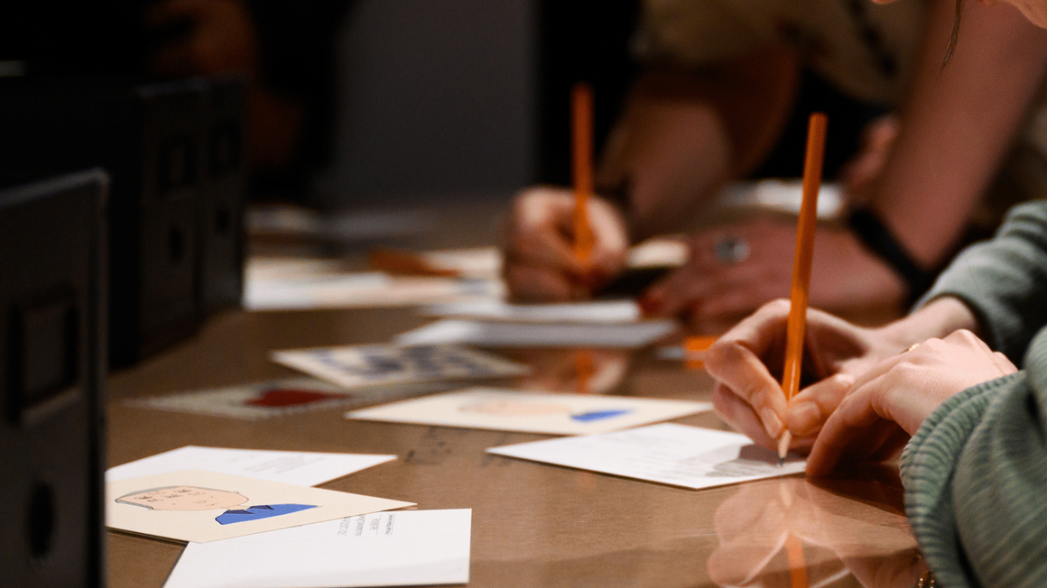 people writing on postcards.
