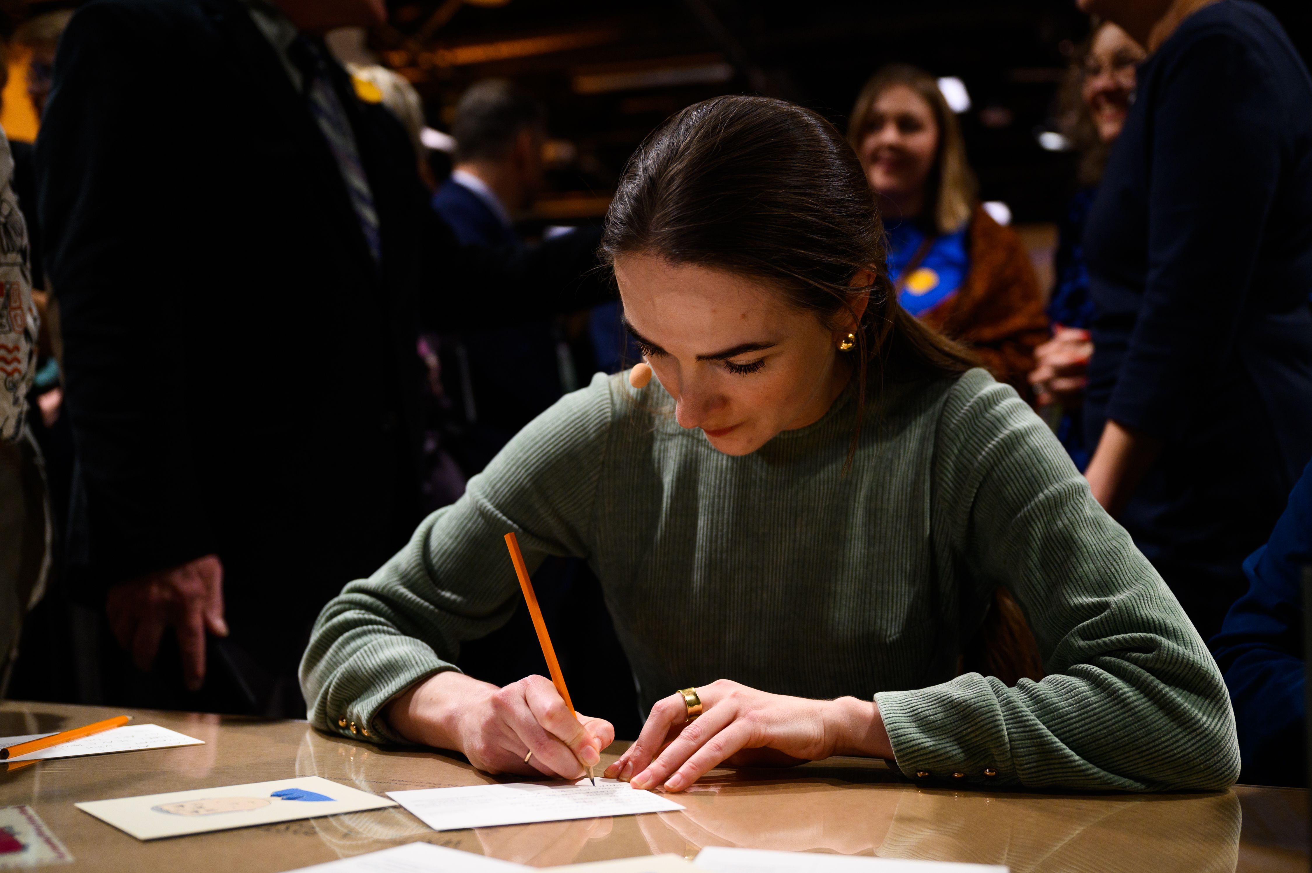 peace prize laureate Oleksandra writing on a postcard