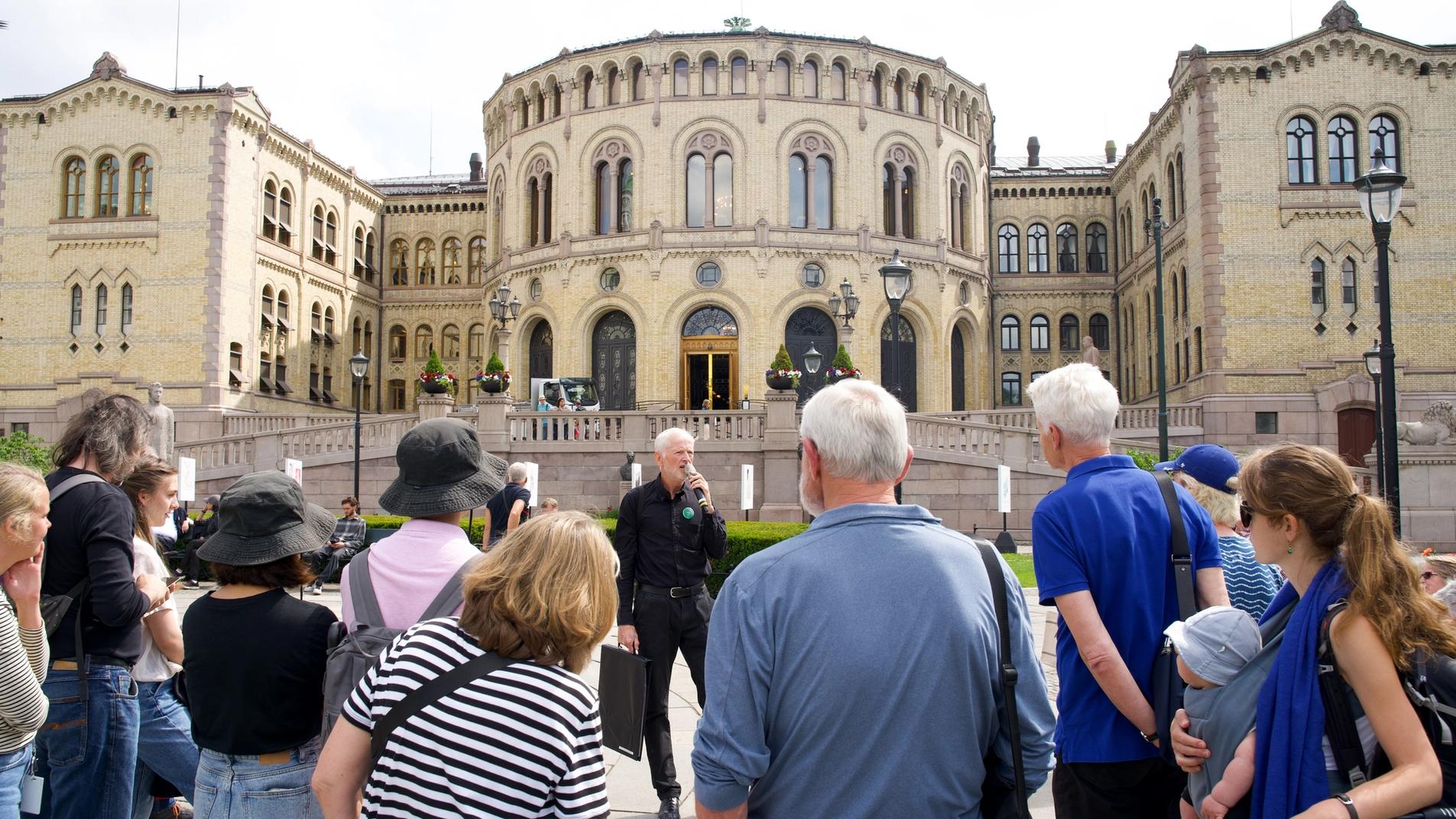 In front of stortinget, with a guide and an audience.