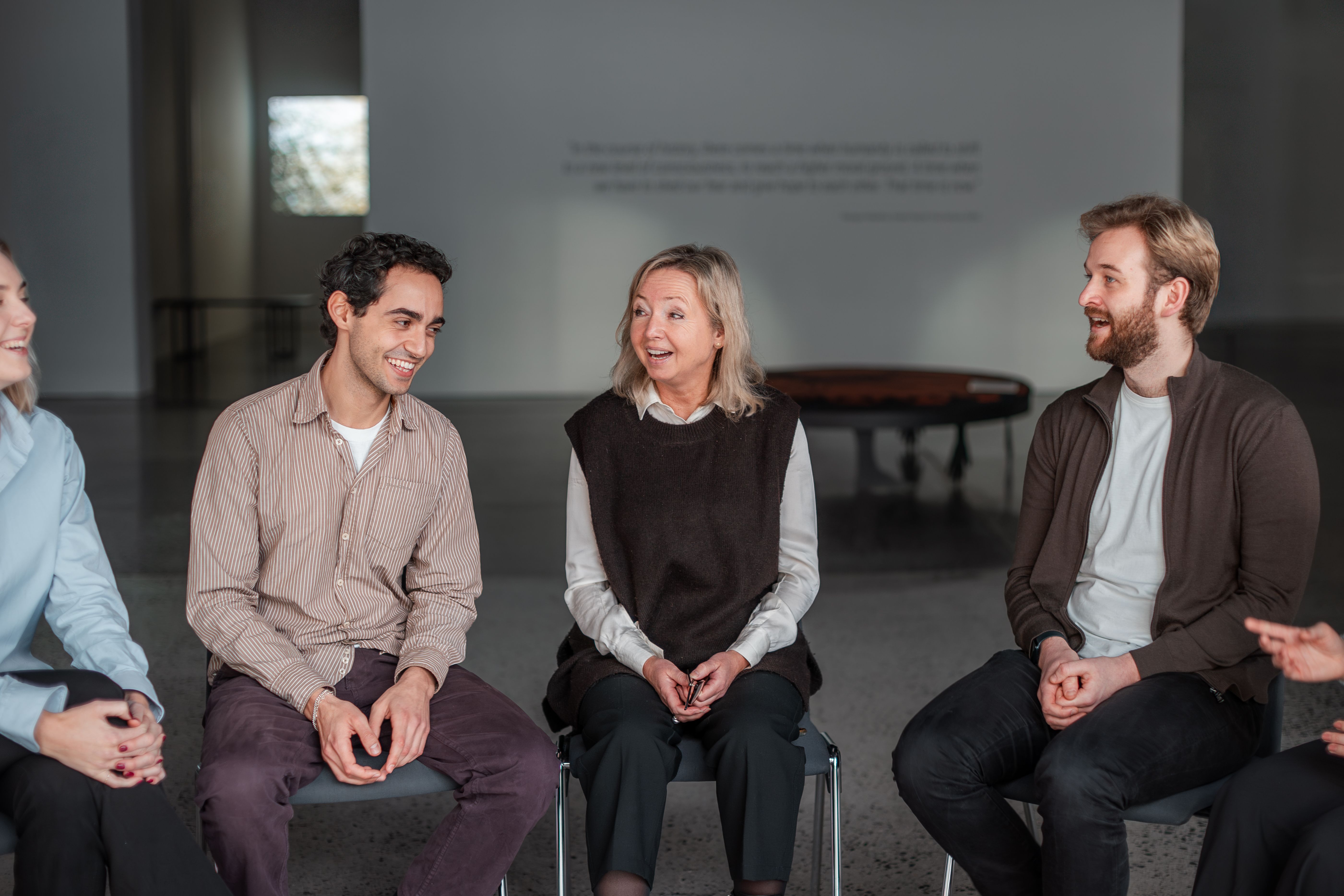 3 people having a conversation, light mood and laughs.