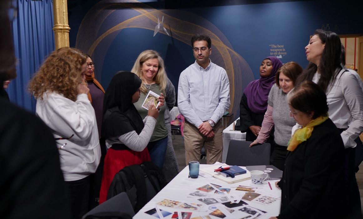 participants gatered around to listen to one participant talk about one of the selected images.