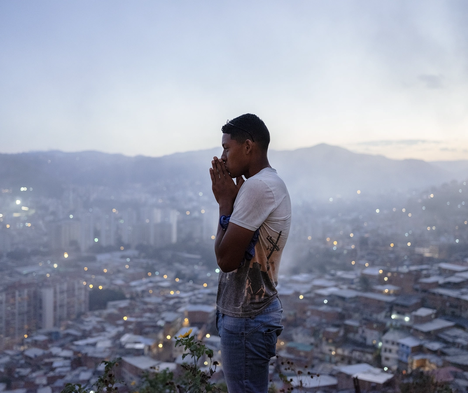 A person standing on a viewpoint in Caracas, Venezuela. In the background is the city.