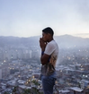 A person standing on a viewpoint in Caracas, Venezuela. In the background is the city.