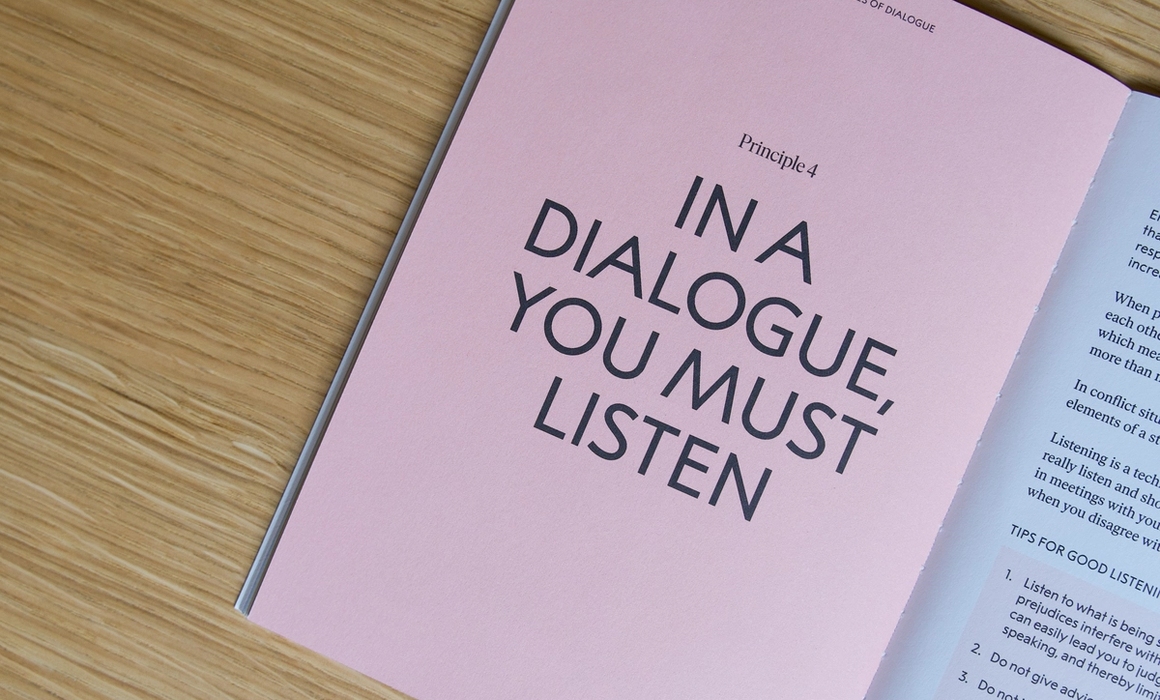 the book open, with a page showing "in dialogue, you must listen".