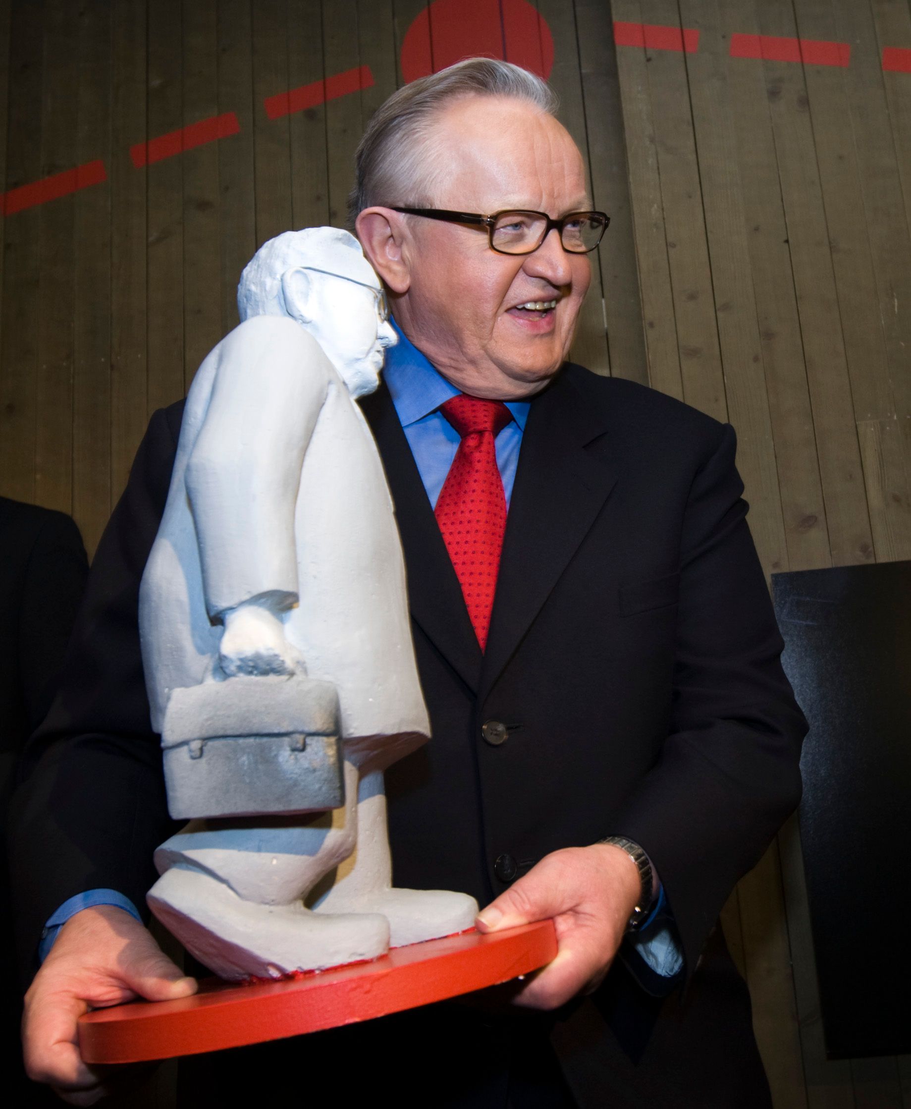 Martti Ahtisaar som holder mini statue av seg selv