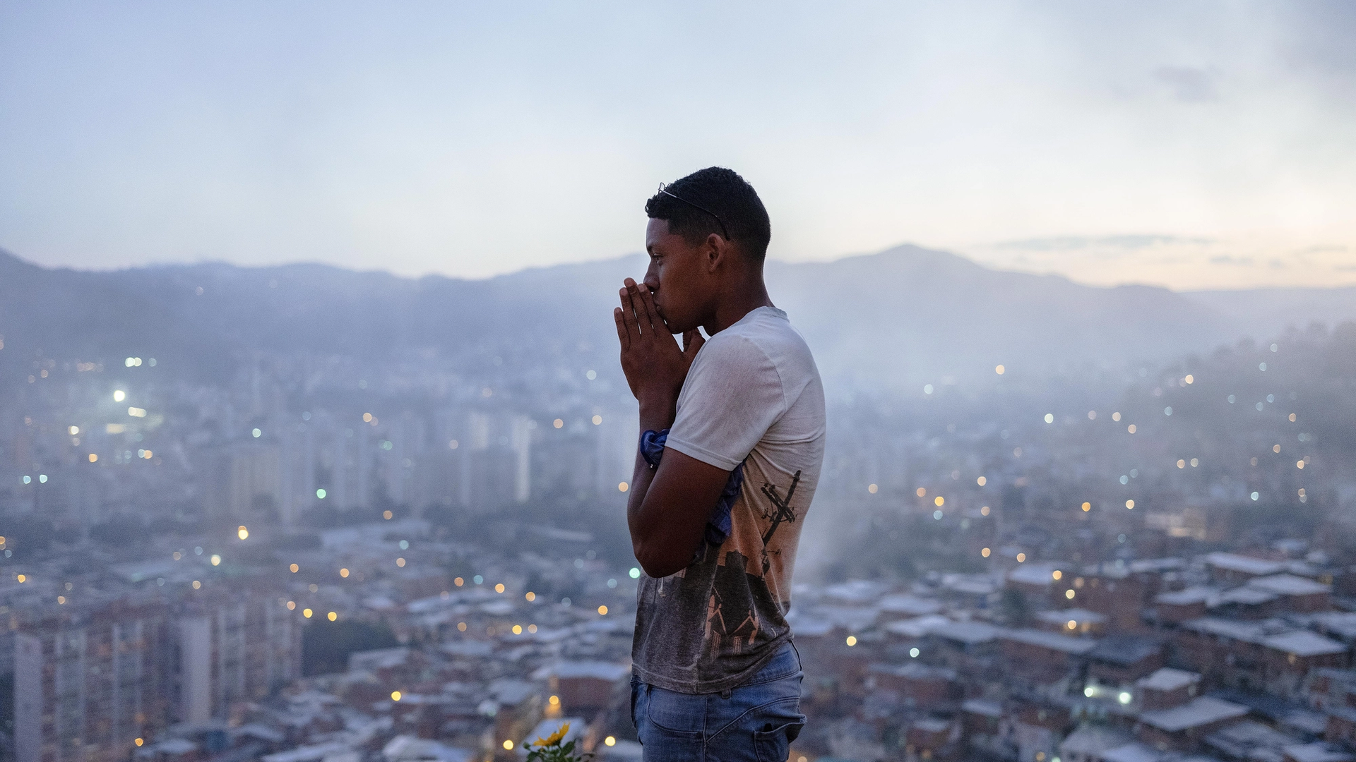 Foto av en mann som står på et utsiktspunkt, bak han ser du caracas.