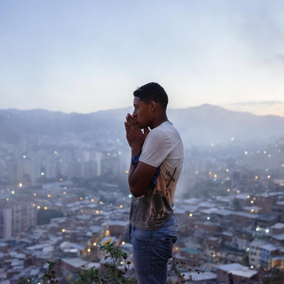 En mann som står på et utstiktspunkt, caracas i bakgrunnen.
