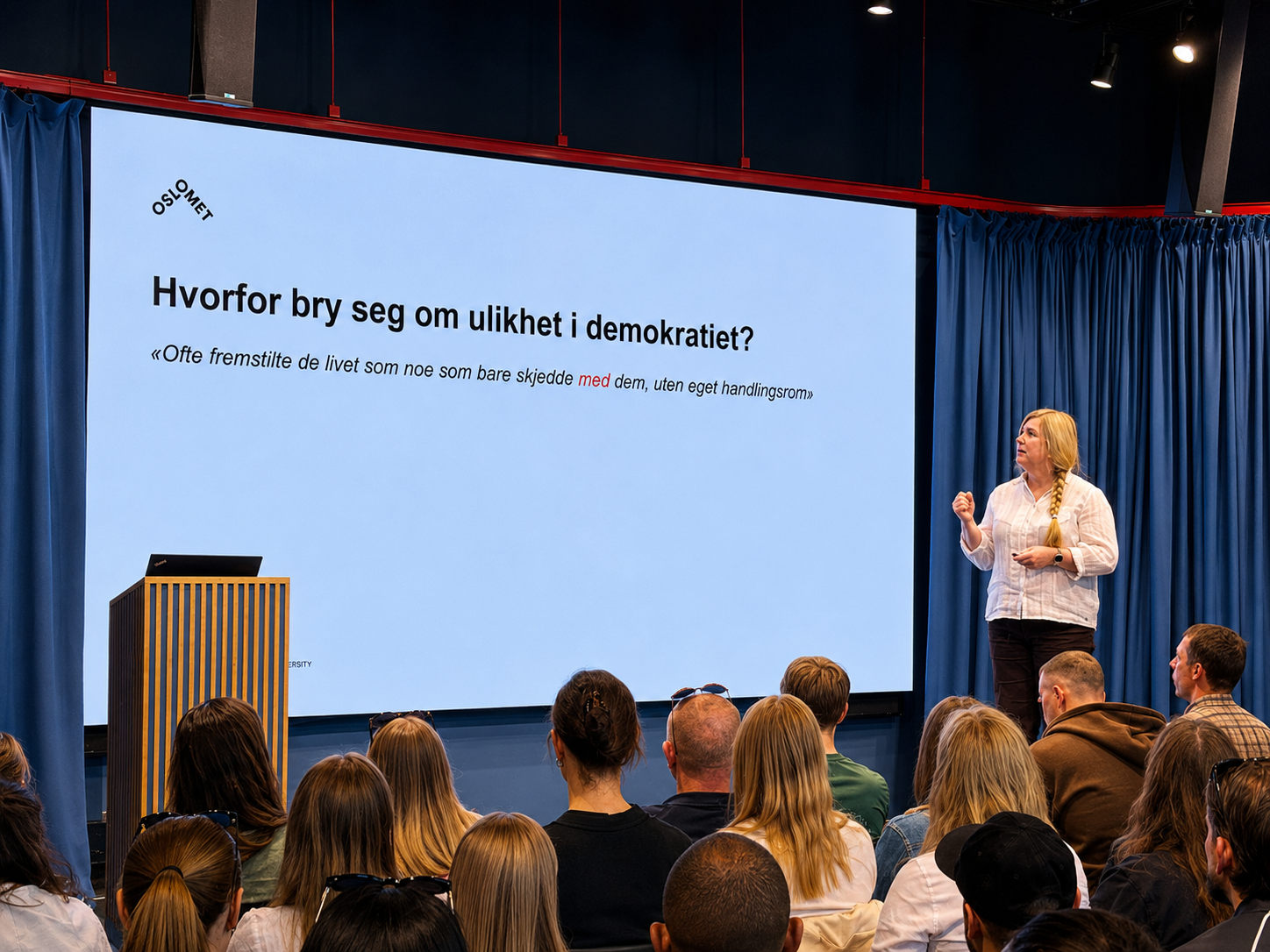 foredrag på scenen, tekst på skjermen sier "hvorfor bry seg om ulikhet i demokratiet"