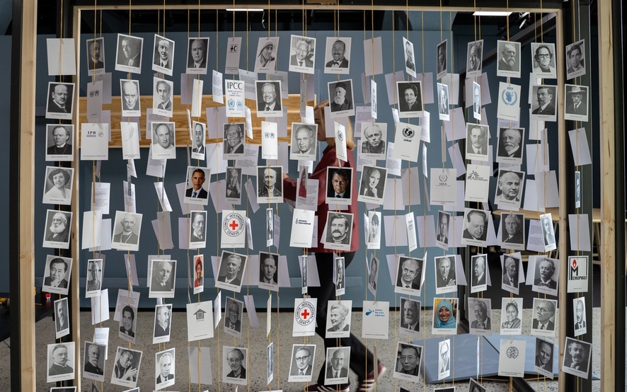 bilde av alle fredsprisvinnerne på kort som henger i tråder, på rekke og rad.