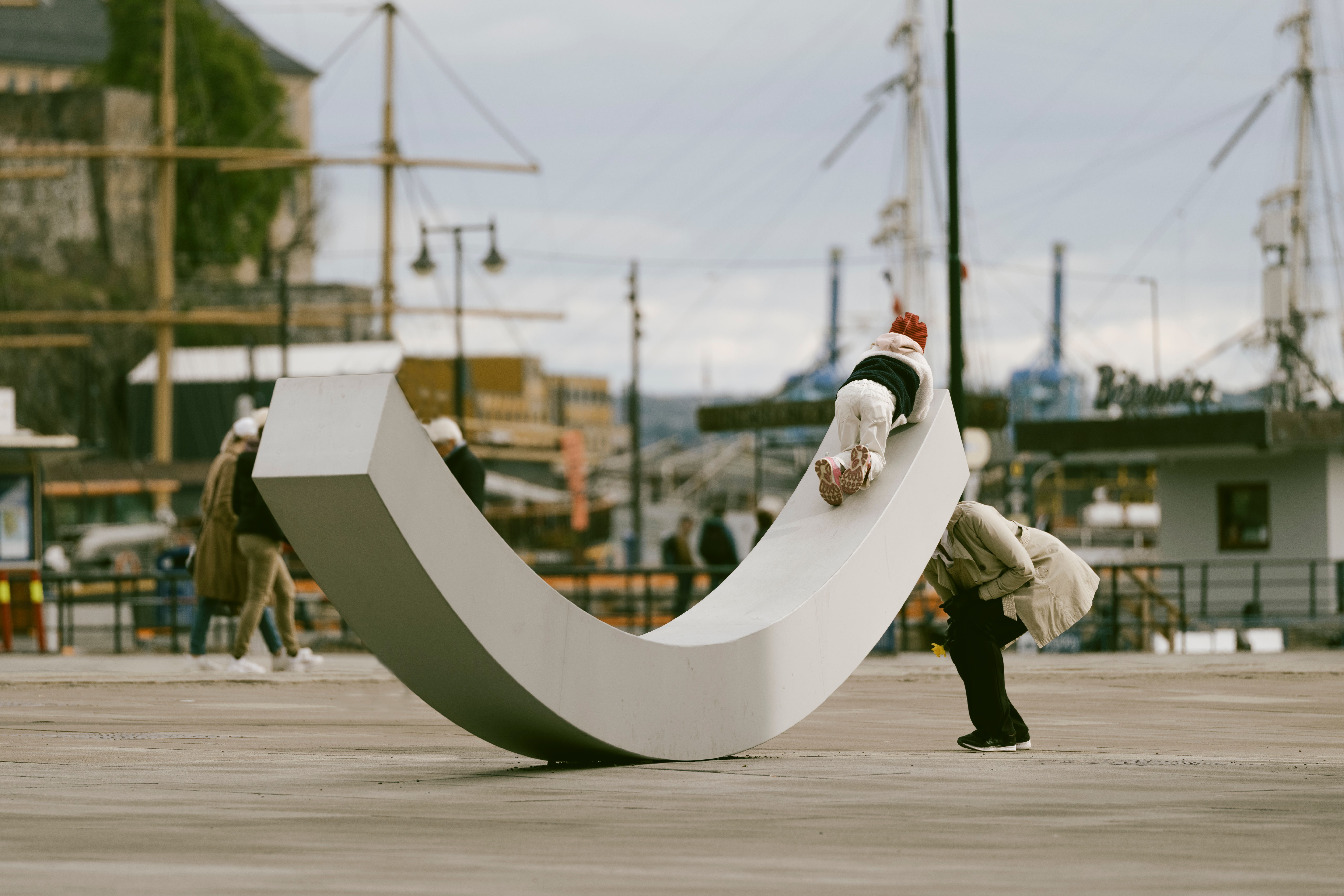 Fasaden til fredssenteret, med fredsbenken og to personer som leker på den.
