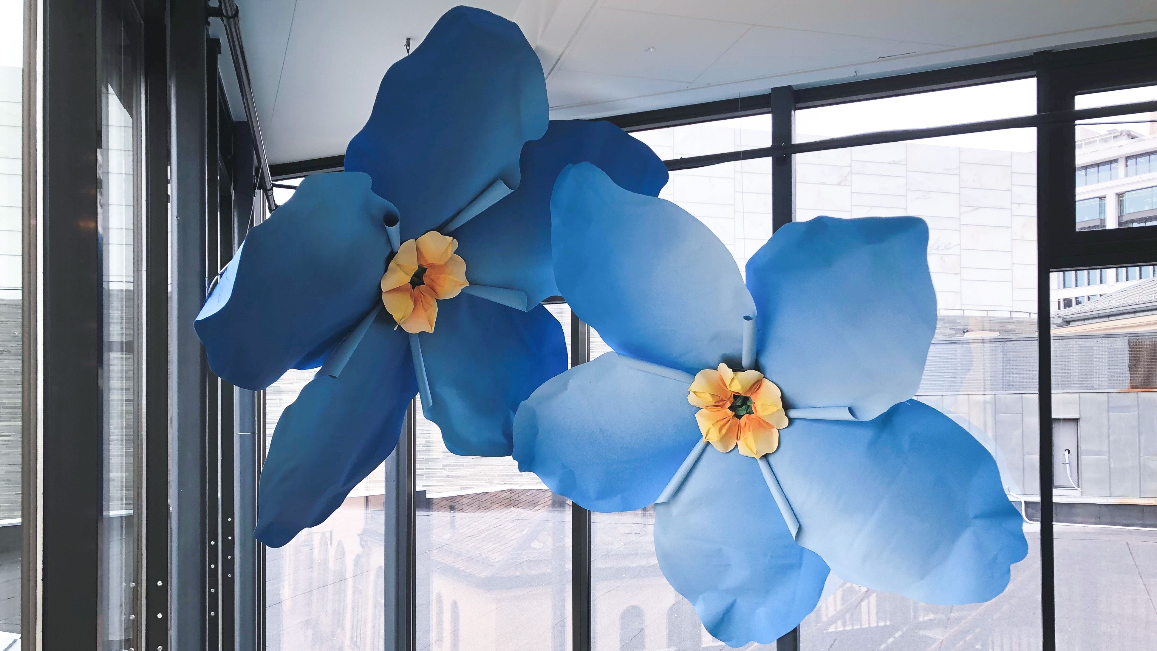 Koroverket, kunstverk av to forglemmeiei blomster i svært stor størrelse som henger fra taket i nobels fredssenter