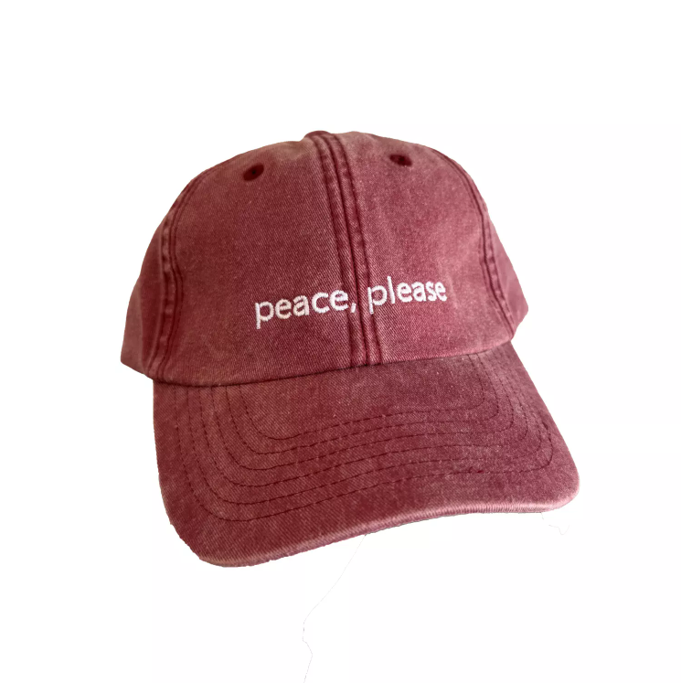 En rød caps med brodert på , peace please.