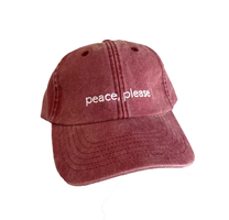 En rød caps med brodert på , peace please.