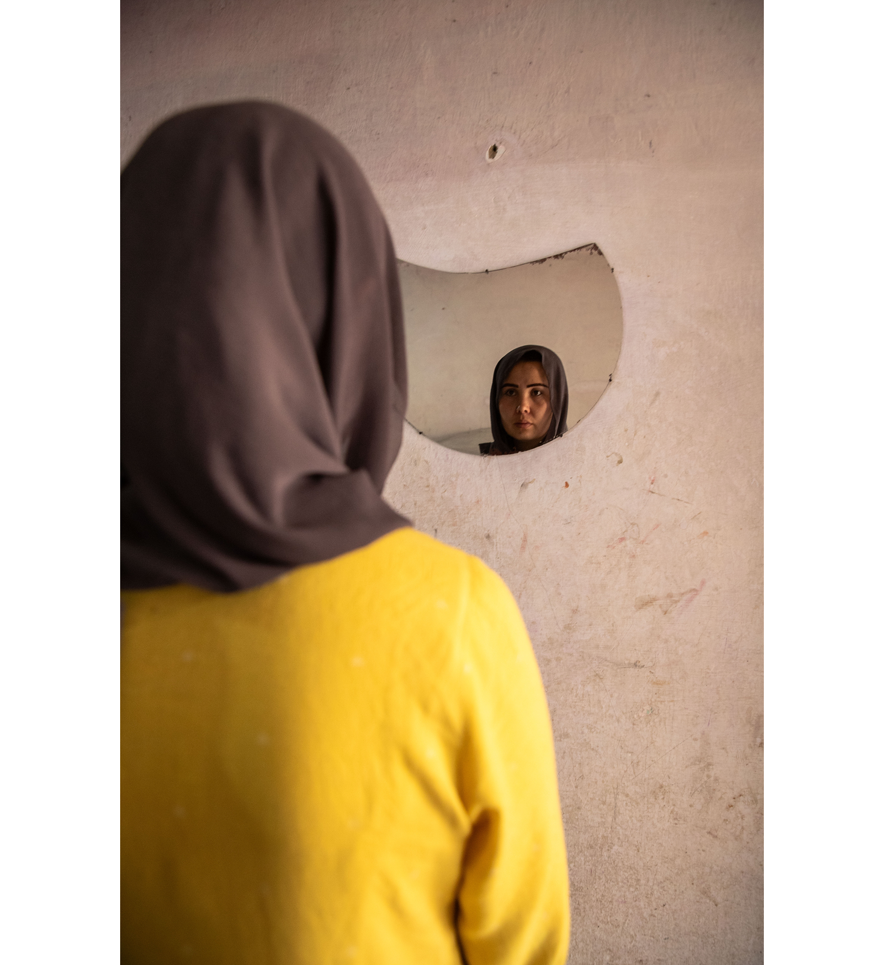 Kvinne som ser seg selv i speilet, et knust speil.