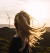 Kvinne som ser utover horisonten med vindmøller