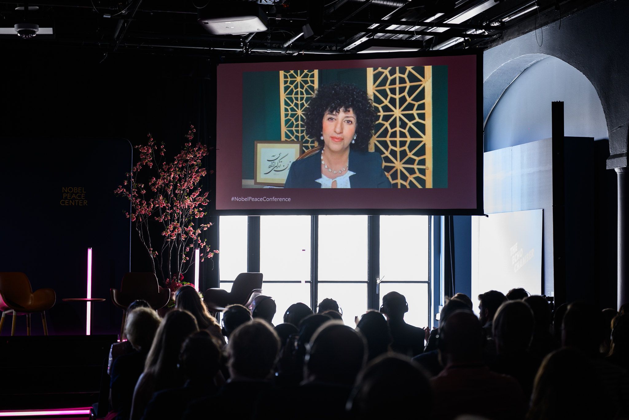 Narges mohammadi på skjerm foran publikum