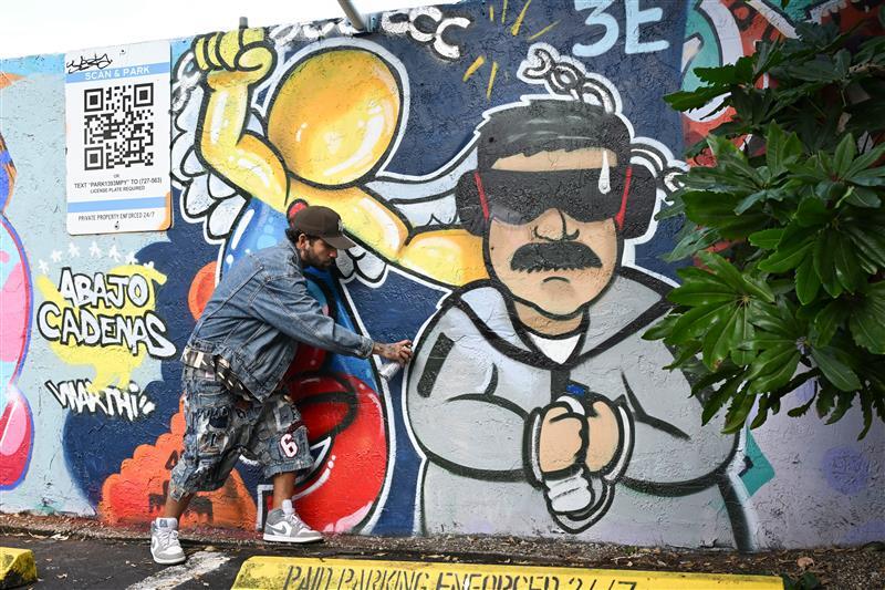 En mann som har laget grafitti bilde av maduro i håndjern.
