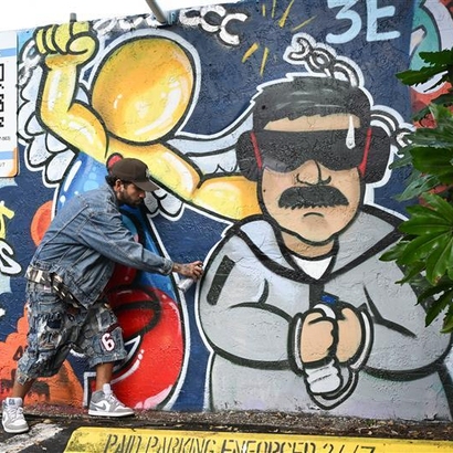 mann som poserer foran tagget bilde av maduro.