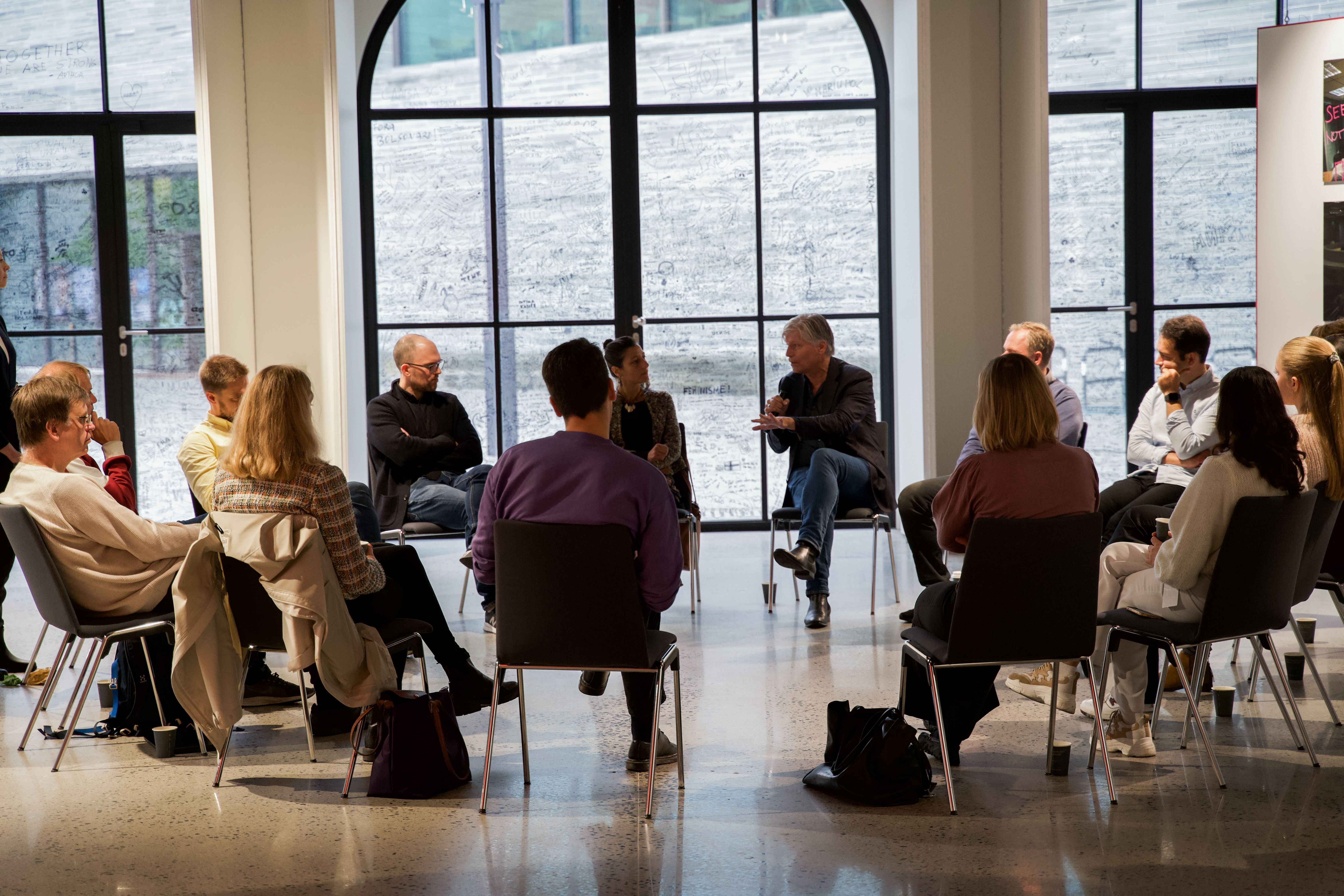 Folk som sitter i en sirkel og har dialogkurs