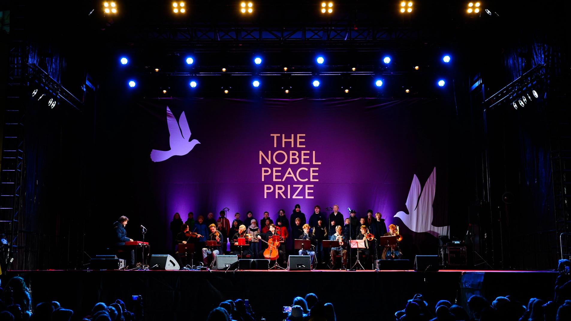 Scenen under bislett guttekor, stor logo i bakgrunnen som sier "the nobel peace prize"