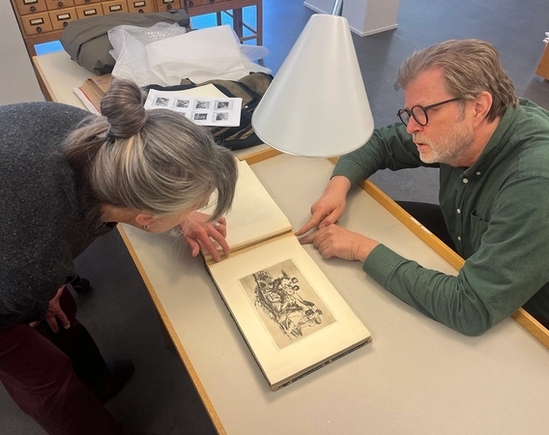 Konservator Linda Barone og hovedbibliotekar Bjørn Vangen bøyd over Francisco Goyas The Disasters of War.