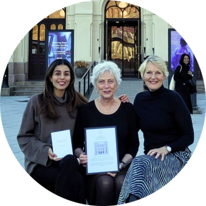 Hilde Henriksen og Mina Adampour sitter foran nobels fredssenter sammen med direktør Kjersti Fløgstad.
