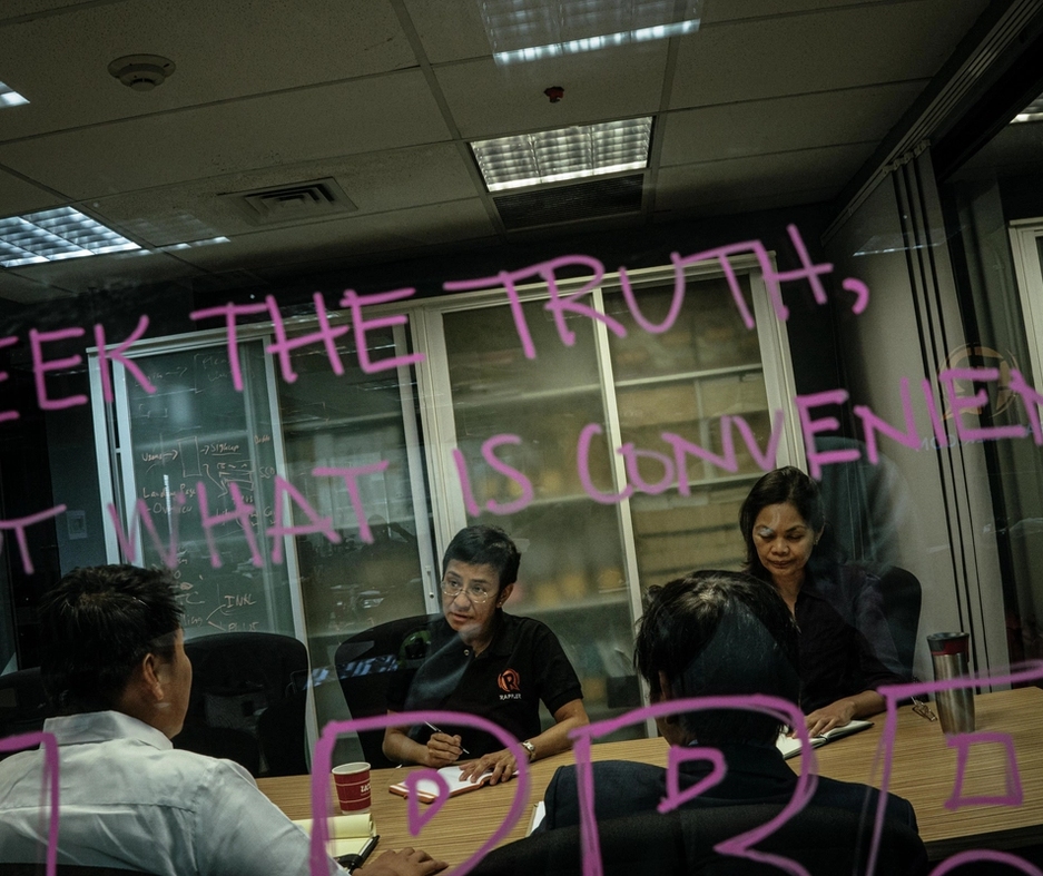 skrift på et vindu "seek the truth, not what is convenient". Maria ressa i bakgrunnen.